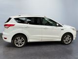 the white ford escape is parked in a large room