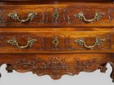 a wooden chest of drawers with ornate carvings on it