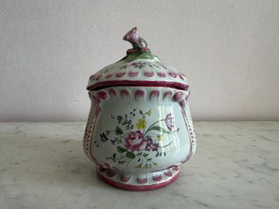 a white and pink vase with a bird on it
