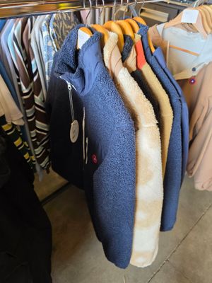 beaucoup de vêtements suspendus à une étagère dans un magasin