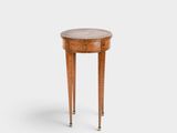 une petite table ronde avec un plateau en marbre et des pieds