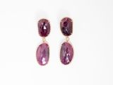 une paire de boucles d'oreilles en pierre violette sur fond blanc