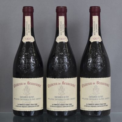 three bottles of wine sit on a glass table with a gray background
