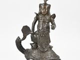 bronze statue of a woman on a turtle with a hat and sword