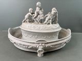 un bol blanc surmonté d'une statuette