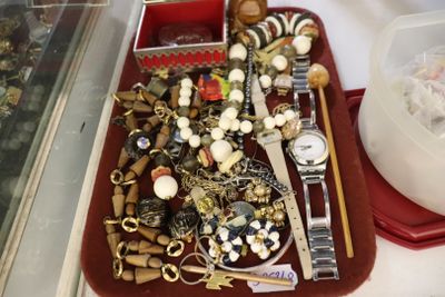 un plateau rouge rempli de bijoux variés posé sur une table