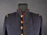 a blue military jacket with red trims and buttons on a mannequin dummy