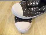 pair of black and white shoes with stars on them on a wooden floor