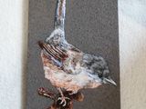 tableau représentant un petit oiseau perché sur une branche d'arbre