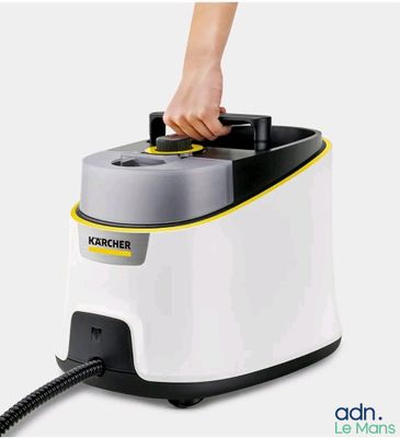 un gros plan d'une personne utilisant un nettoyeur à vapeur sur une surface blanche