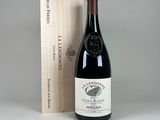 the bottle of wine is next to a wooden box