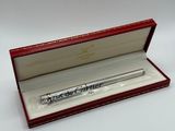 un gros plan d'un stylo dans une boîte rouge posée sur une surface blanche