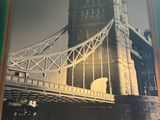 a picture of a picture of a bridge hanging on a wall