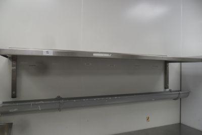 a stainless steel shelf in the middle of a kitchen