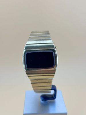 une Apple Watch posée sur un socle métallique, sur une table