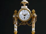 une horloge blanche et dorée posée sur une table en bois