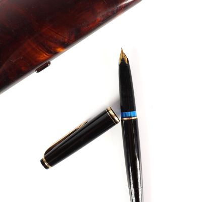 un stylo posé sur une table à côté d'un autre stylo
