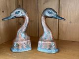 deux statues de canards posées sur une étagère dans une pièce