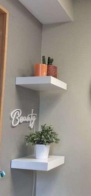 une horloge accrochée au mur au-dessus d'une étagère dans une salle de bains