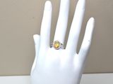 une main de mannequin blanche ornée d'une bague jaune