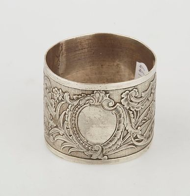 an antique silver napkin ring with a floral design on it