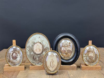 six œuvres d'art exposées sur une table avec un fond noir