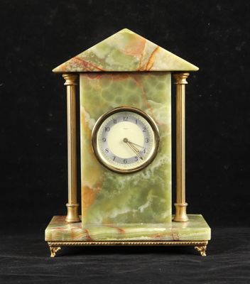 une image représentant une horloge en marbre vert posée sur une table