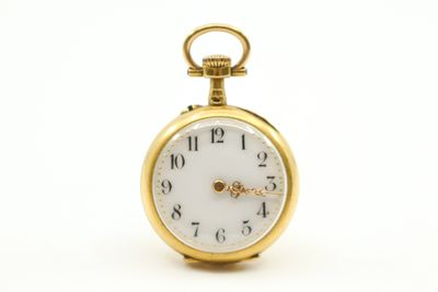 gros plan d'une montre de poche en or sur fond blanc