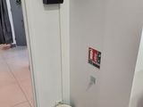 doorway view of a room with a white wall and a black speaker on the wall