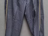 un pantalon gris avec des fermetures éclair jaunes, suspendu à un cintre