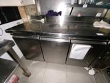 a kitchen with a stainless steel counter top and black cabinets