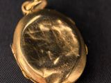 an antique gold pocket watch on a black background