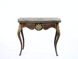 une petite table avec un plateau en marbre et des décorations à la feuille d'or
