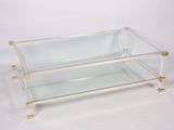 une table basse en verre et en laiton sur fond blanc