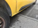 a close up of a yellow truck parked in a parking lot