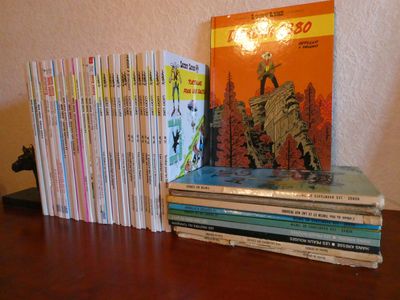 une pile de livres posée sur une table à côté d'une lampe