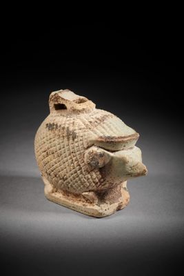 an old clay figurine of a head with a bird on it