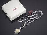 un gros plan sur un coffret sur lequel sont posés une chaîne et une montre