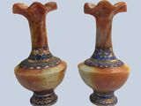pair of vases sitting on top of each other on a blue surface