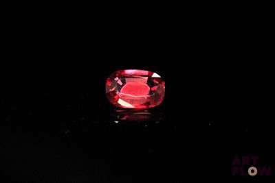 a close up of a red diamond on a black surface