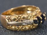 a close up of a gold ring with a blue stone