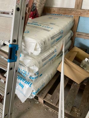 un homme qui se tient à côté d'une pile de sacs