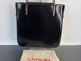 an image of a black handbag sitting on top of a table
