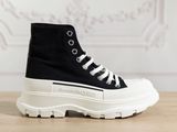 des baskets montantes noires et blanches à semelles blanches posées sur une table en bois