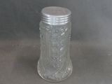 a glass jar with a silver lid sitting on a table