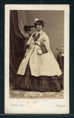 une vieille photo d'une femme en robe et avec un chapeau