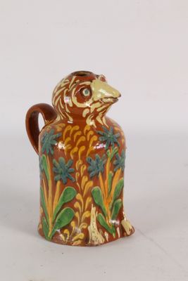 a brown and green vase with a bird on it