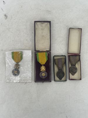 three medals and a ribbon in a case on a white surface