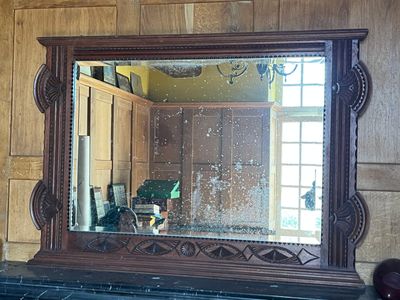 a mirror that is on a mantle in a room