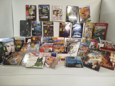 beaucoup de DVD et de films posés sur une table blanche